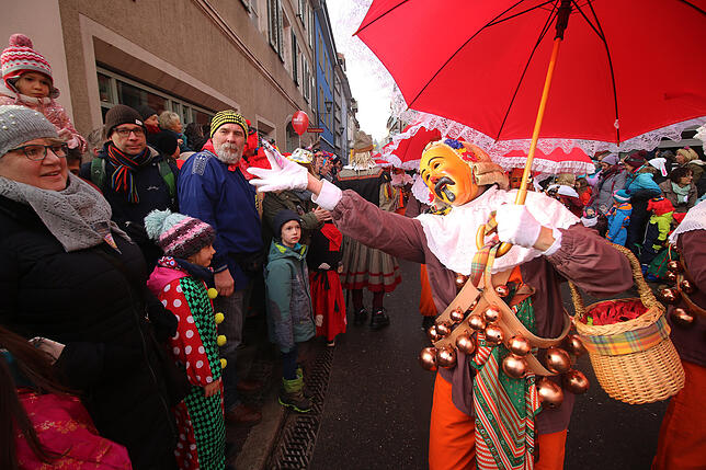 Kann man da widerstehen? Ein Oberndorfer Hansel bietet einem Besucher des großen Umzuges beim Narrentag in Überlingen eine Süßigkeit an.