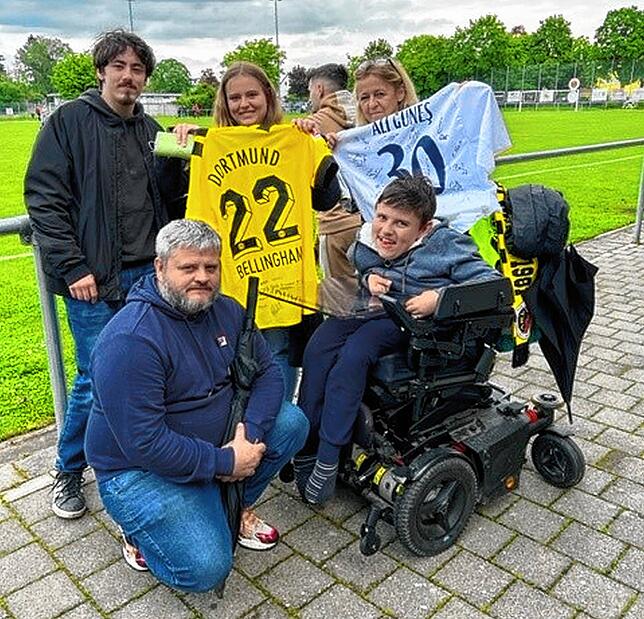 Lenny freut sich mit seiner Familie über die Trikots.