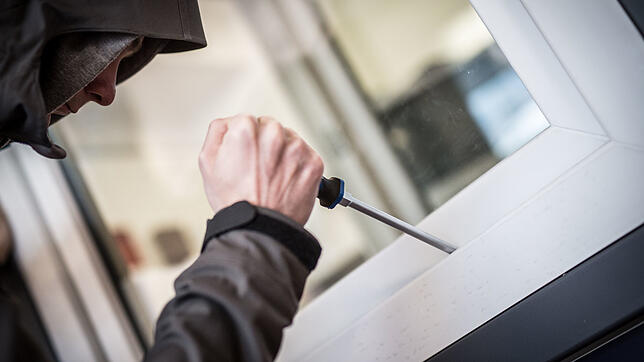 Ein Mann demonstriert in einer polizeilichen Beratungsstelle, wie Einbrecher Fenster aufhebeln.