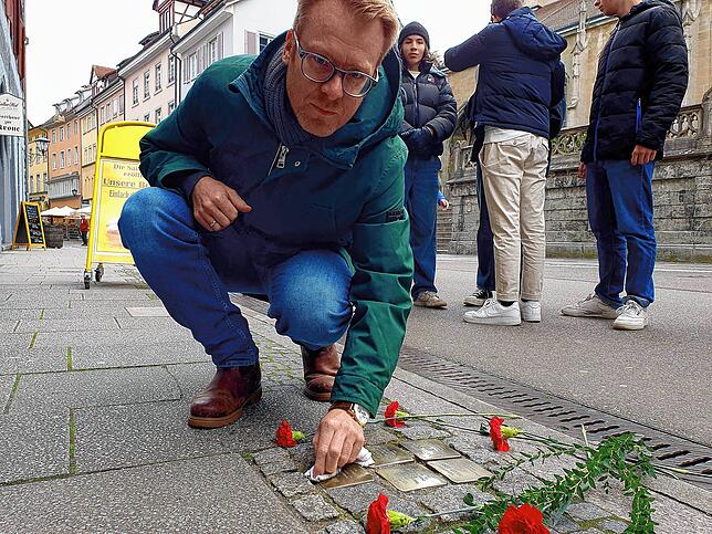Gedenken an NS-Opfer aus Überlingen: Patrick Konopka, Geschichtslehrer am Gymnasium Überlingen, beim Reinigen von Stolpersteinen in der ...