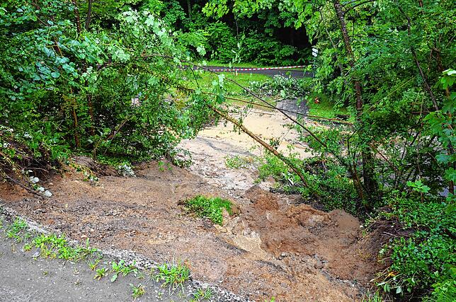 Blick von der Abbruchkante zur Töbelestraße. Noch immer fließt Wasser aus dem Hang die Straße hinunter.