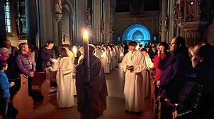 Einzug der Lichterprozession in das Münster. Pfarrer Bernd Walter mit der kurz zuvor am Osterfeuer entzündeten Osterkerze. Gefolgt von ...