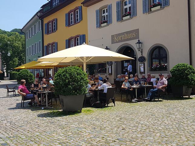 In der Altstadt Staufens sitzen viele Menschen vor dem Kornhaus, einem Café schräg gegenüber vom Rathaus. Touristen kommen gerne hierher ...