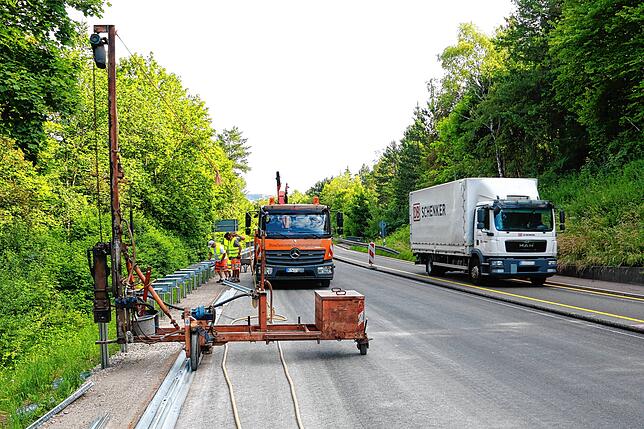 Während auf der einen Fahrbahnseite der Verkehr rollt, montieren die Arbeiter entlang des bereits sanierten und schon wieder ...