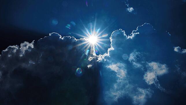 Die Sonne scheint am Rand von dunklen Wolken. In den kommenden Tagen wird in Bayern das Wetter wieder freundlicher. (Archivbild vom ...