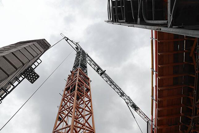 Auf der Baustelle stehen zwei Kräne, doch in keinem sitzt ein echter Mensch.