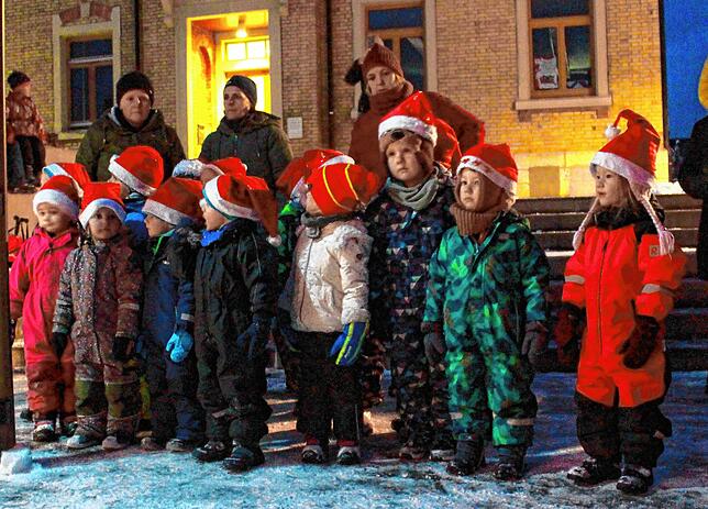 Die Kinder lauschen gemeinsam mit ihren Eltern den adventlichen Klängen der Musiker und stimmen fröhlich in den Gesang ein.