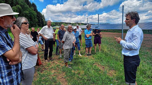 Markus Wankel, der Projektleiter der des Investors Baywa (rechts), erläutert Besuchern den Solarpark bei den Spitalhöfen.