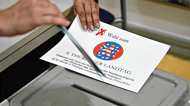 Eine Wählerin steckt den Stimmzettel in die Wahlurne in einem Erfurter Wahllokal.