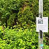 An einer Straßenlaterne hängt der Warnhinweis vor Giftködern.