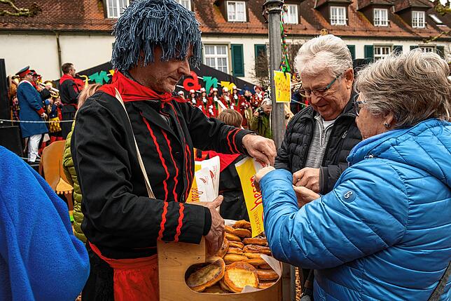 Markus Eckardt verkauft Dietmar und Monika Lohr Hexenküchle aus seinem Bauchladen.