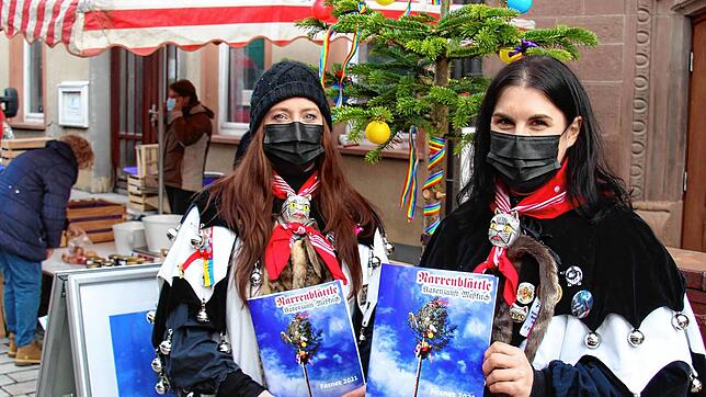Sabrina Matheis (links) und Andrea Ott verkauften das Narrenblättle der Meßkircher Katzenzunft auf dem Wochenmarkt.