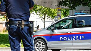 10.06.2025, Österreich, Graz: Ein Polizist steht in der Nähe des Tatorts. Die Polizei ist im Großeinsatz in einer Grazer Schule in der ...