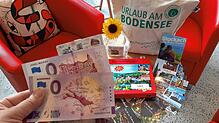 Auf dem Tisch sind Postkarten, ein Memory, Brettchen, Magnet, Schlüsselanhänger und Wanderkarte von Stockach sowie eine Tasche. ...