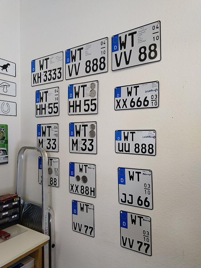 Autokennzeichen in allen möglichen Formen hängen an der Wand der Kroschke-Filiale in Bad Säckingen.