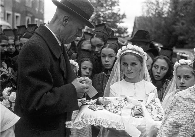 Religiöse Bräuche sind tief verwurzelt: Dieses Foto von einer Erstkommunion entstand 1950. Das Mädchen trägt auf dem Kissen eine Puppe ...