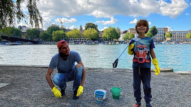 Vater Thomas Betzler mit Sohn Timo finden an nur einer Stelle ganz viel. Mit Gummihandschuhen und Greifzange lesen sie es auf und ...