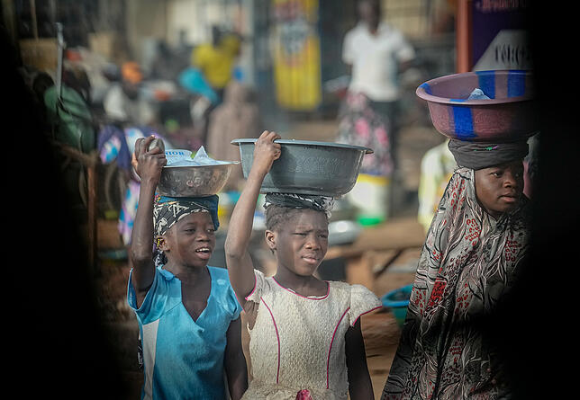 Malische Mädchen stehen im April mit Schüsseln auf dem Kopf am Straßenrand in Bamako, der Hauptstadt Malis, bei der Durchfahrt einer ...