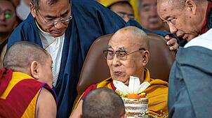 Das geistige Oberhaupt Tibets, der Dalai Lama (M), isst eine Torte während der Feierlichkeiten zu seinem 90. Geburtstag im ...