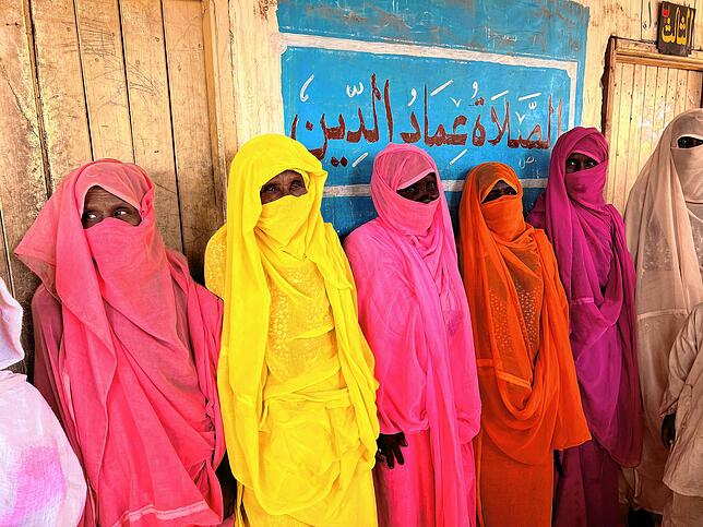 Frauen in Sinkat im Sudan, die traditionell bunte Kleidung zu Ehren der heiligen Mariam tragen.