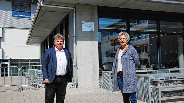 Die Schulleiter Holger Seitz und Beate Clot stehen auf dem Pausenhof des Schulverbunds Nellenburg. Links im Hintergrund ist ein ...