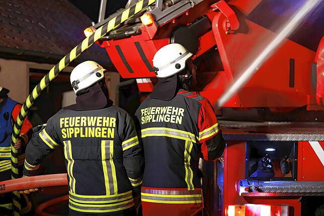 Die Löschwasserleitung steht, über zwei Drehleitern wird der Dachstuhlbrand von oben bekämpft.