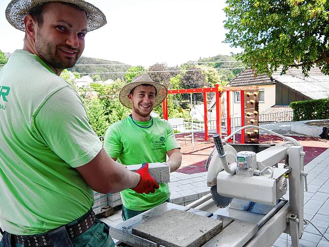 Auf der Zielgeraden: Frank Wangler (links) und Dirk Pfanner (rechts) verlegen die letzten Steine für die Außenanlage der Schule in ...