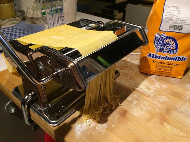 Die Pasta-Maschine walzt den Teig dünn aus und formt danach daraus lange Nudeln.