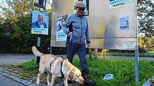 Am 10. November sind in Überlingen OB-Wahlen. Ein Mann geht mit seinem Hund an einer Plakatwand in der Ortschaft Bambergen vorüber.