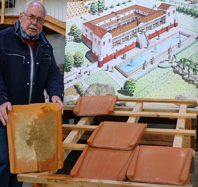 Helmut Bauckner vom Verein für Heimatgeschichte mit einem gut erhaltenen originalen römischen Dachziegel vor der Rekonstruktion der ...
