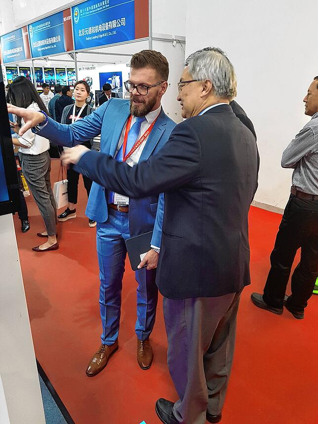 Geschäftsführer Dirk Grassinger im Kundengespräch auf der Internationalen Ausstellung für Werkzeugmaschinen 2019 in Peking.