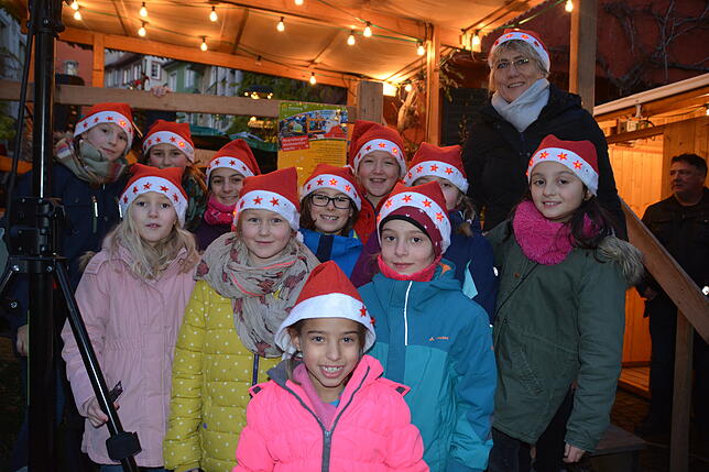 Einheitlich mit blinkenden Nikolausmützen: Der Kinder- und Jugendchor der katholischen Kirche unter Leitung von Olga Brugger (rechts ...