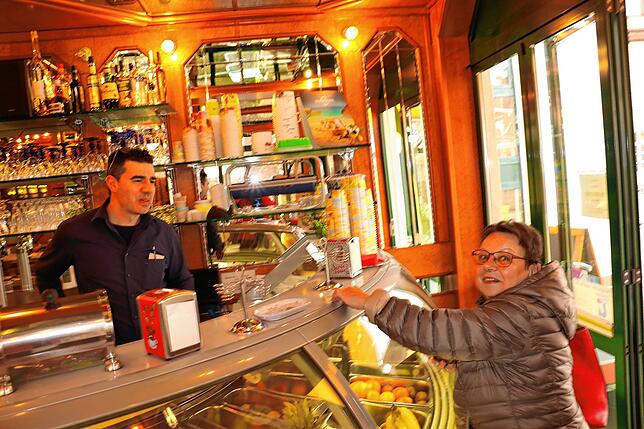 Massimiliano Longo gibt Marianne Hauser das Wechselgeld heraus. Sie hat im Eiscafé Rialto einen Kaffee getrunken.