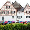 Viele beschirmte Interessierte nahmen bei Regenwetter am Informations-Spaziergang teil. Das Bild zeigt die Gruppe vor dem Strobel-Haus ...
