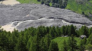 Wasser aus dem Fluss Lonza fließt über Schlamm und Stein, nachdem sich ein See auf den letzten Häusern des Dorfes Blatten gebildet hat. ...