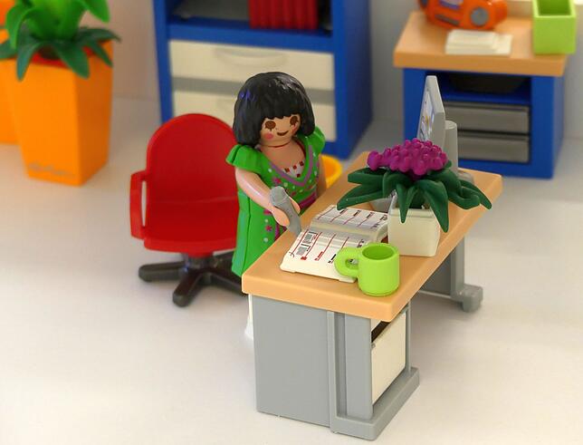 OB Dorothee Eisenlohr als Playmobil im Diorama-Rathaus mit einem Schreibgerät aus Tennenbronn.