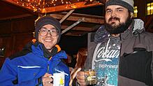 Fabian Kiewning und Felix Ebner genießen heißen Glühwein auf dem Singener Weihnachtsmarkt.