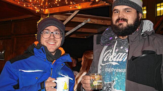 Fabian Kiewning und Felix Ebner genießen heißen Glühwein auf dem Singener Weihnachtsmarkt.