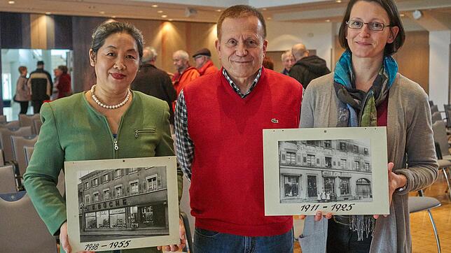 Zeitreise: Liping Li (von links), Reinhard Valenta und Gabriele Volk mit Bildern der alten Schuhhandlung Büche in der Hauptstraße 35, ...