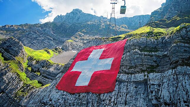Ist die Schweiz freiheitlicher als Deutschland? Das Bild zeigt, wie am Bundesfeiertag eine Flagge unterhalb des Säntis angebracht wird.