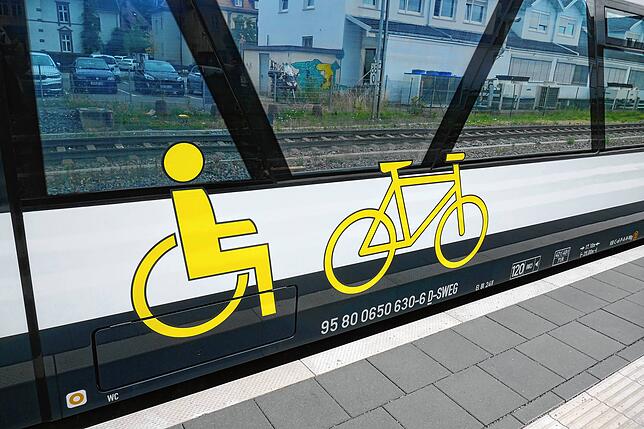 Deutliche Logos weißen auf die Tür hin, wo mobilitätseingeschränkte Fahrgäste und Radfahrer einsteigen können.