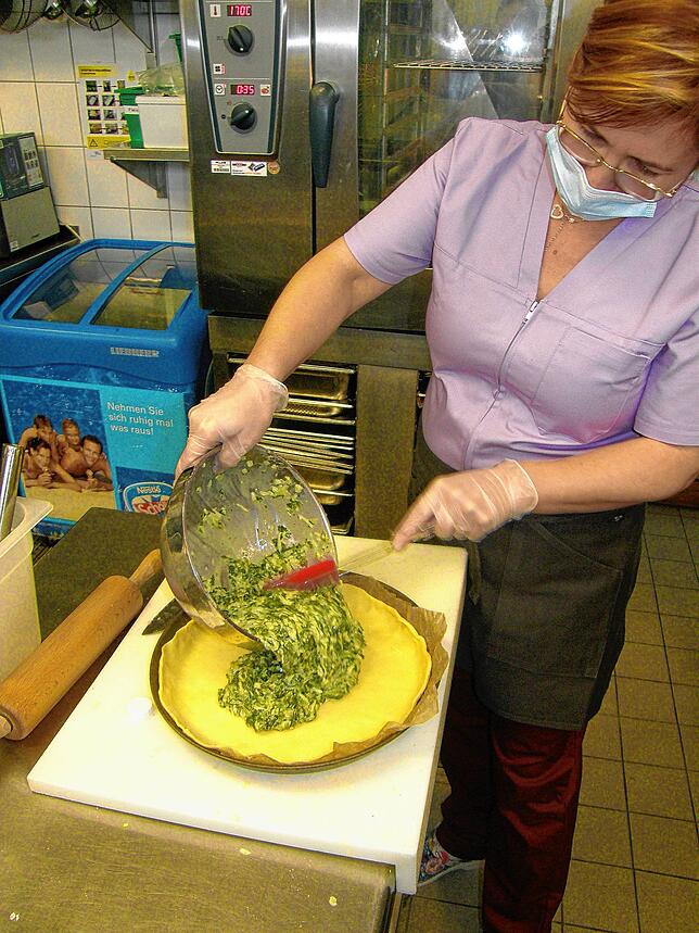 6. Nun wird die Eier-Sahne-Spinat-Mischung auf den Teig in der Kuchenform gegeben. Dann die Masse gleichmäßig verteilen und mit etwas ...