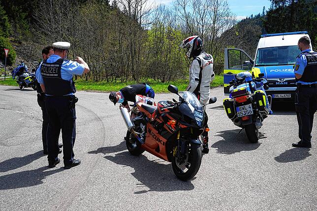 Stimmt alles mit dem Auspuff? Der Polizist schaut genauer hin.