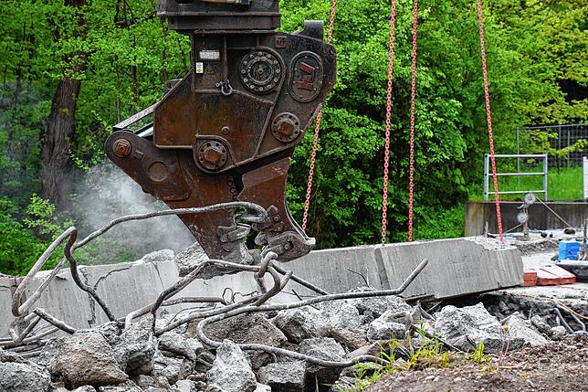 Dieser Baggeraufsatz, der wie ein Dino-Kopf aussieht, zerkleinert den Beton, in dem die Stahl-Bewährung der Brücke verbaut ist.