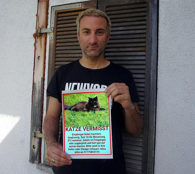 Davide Martello mit dem Flugblatt, mit dem er nach seinem verschwundenen Kater Salem sucht, auf dem Foto trägt der Kater einen weißen ...