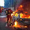 Feuerwehrleute löschen ein brennendes Auto am Rande von Ausschreitungen in Nanterre westlich von Paris.