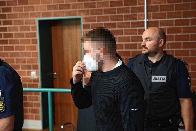 Justizmitarbeiter bringen einen der vier Angeklagten in die Verhandlung.