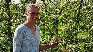 Bettina Arnold steht an einigen Apfelbäumen auf dem Hof in Friedrichshafen-Kluftern.
