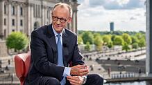 Bundeskanzler Friedrich Merz (CDU) sitzt nach dem ARD-„Sommerinterview“ vor dem Bundestag.