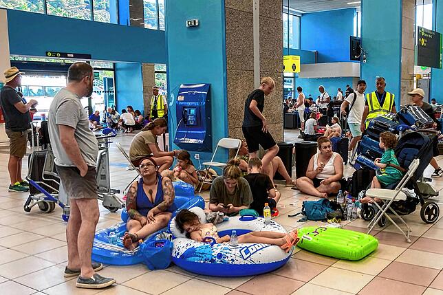 Touristen warten am Flughafen Rhodos. Wegen der Waldbrände sind auf der griechischen Insel fast 20.000 Menschen in Sicherheit gebracht ...